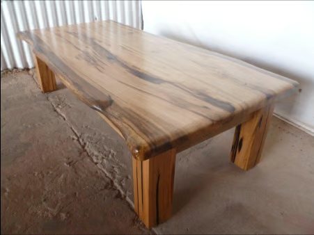 A wooden table standing on a stained concrete floor
